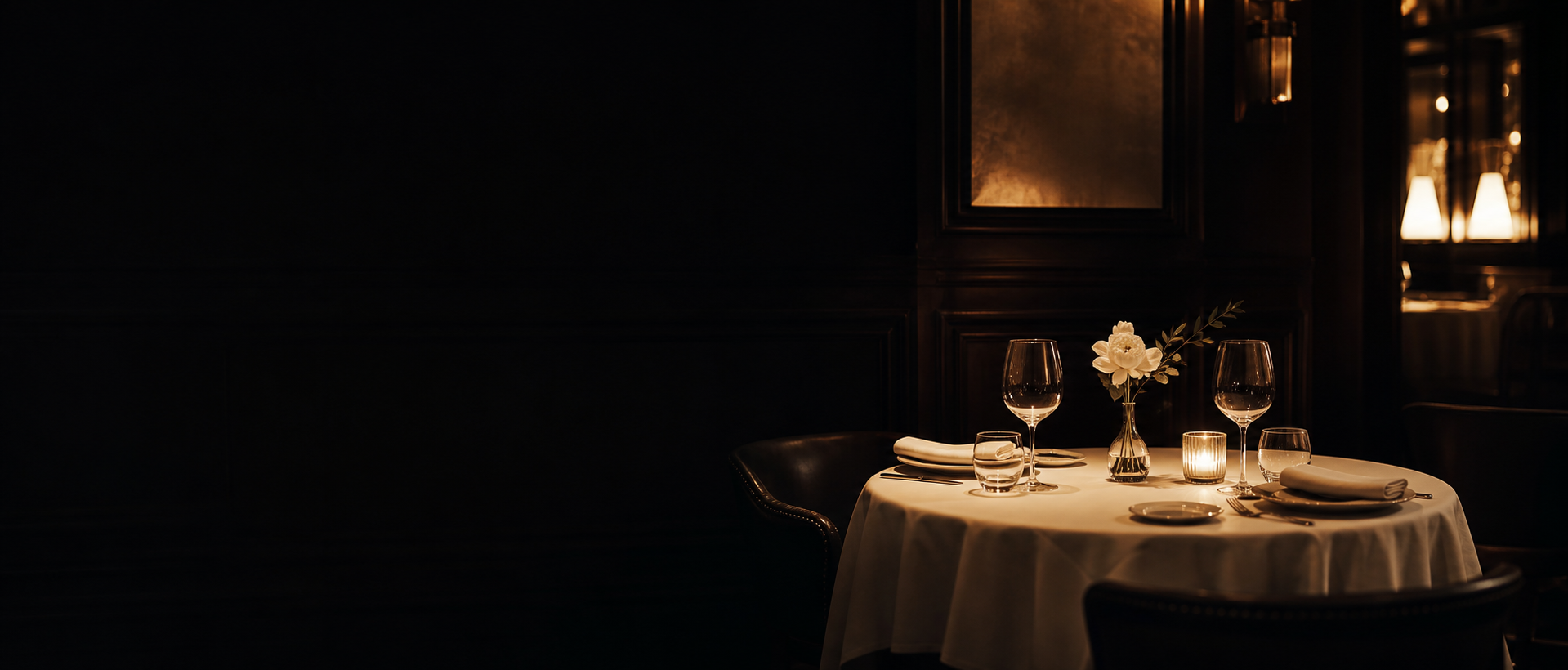 An intimate table set for two beneath a brass pendant in Nocturnal’s dining room